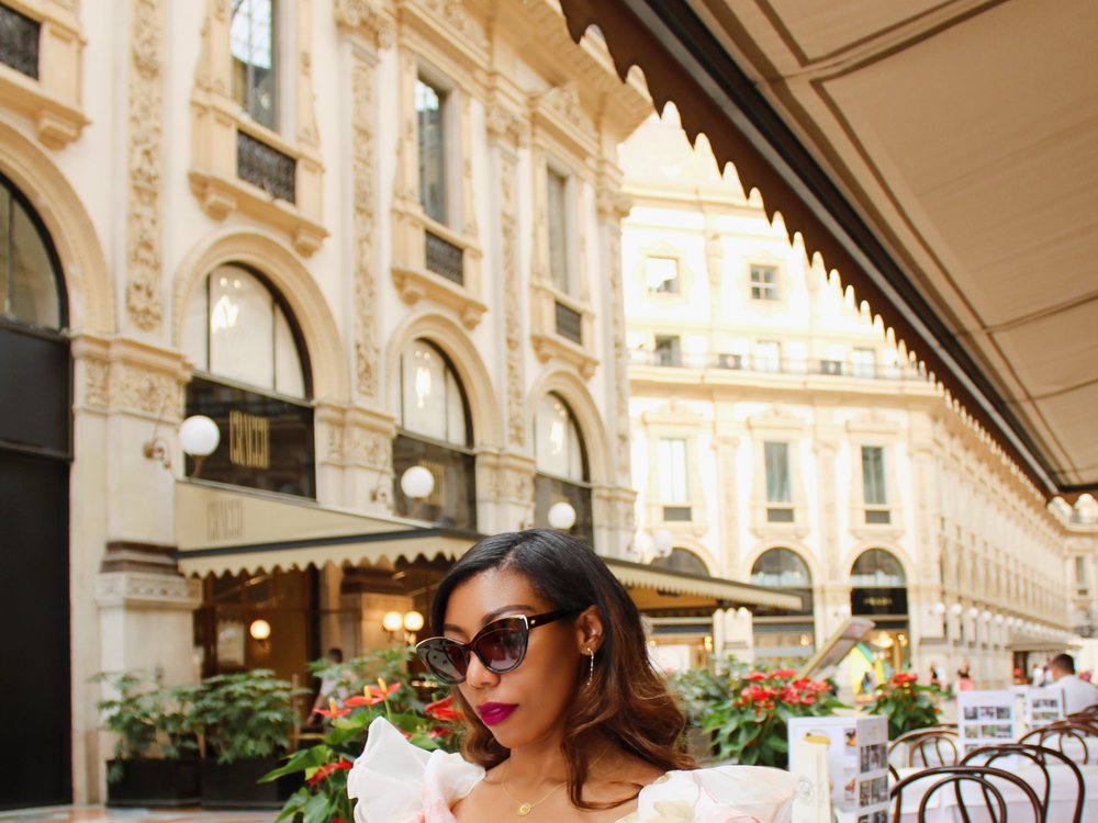 Chilen at a café table beneath the arcades of Milan